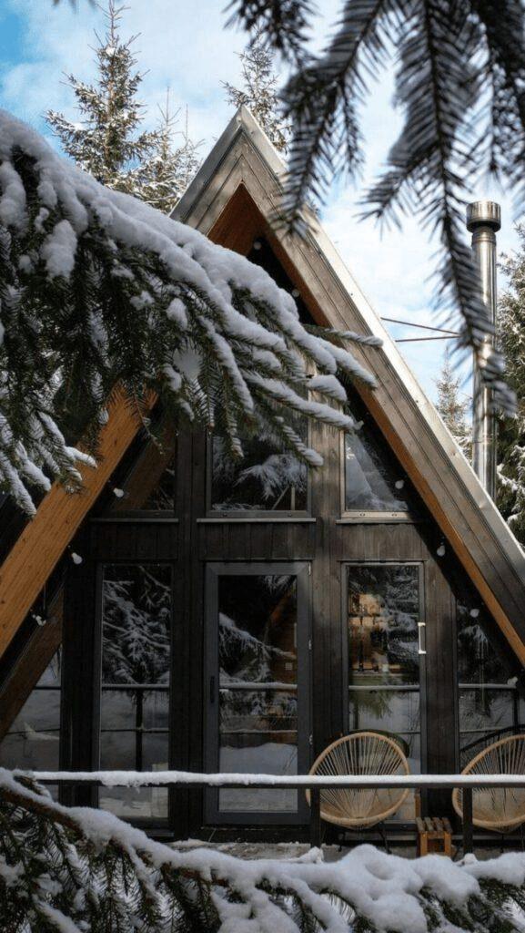 A-frame дом с панорамными окнами в заснеженном ельнике — остановка в начале Золотого кольца